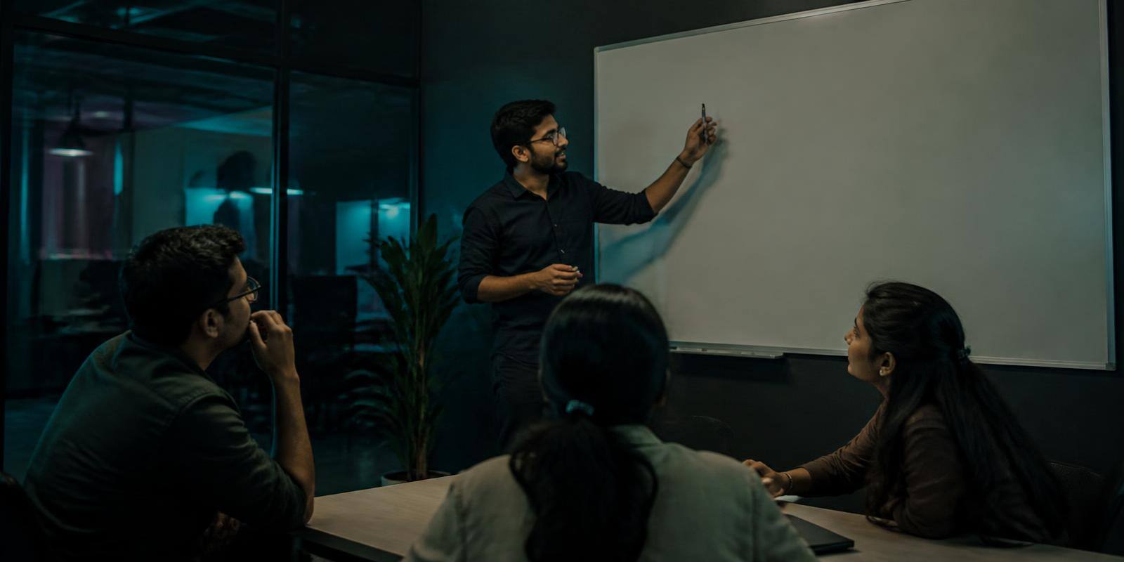 Members of the Alliance India team in a working session around a whiteboard in their office